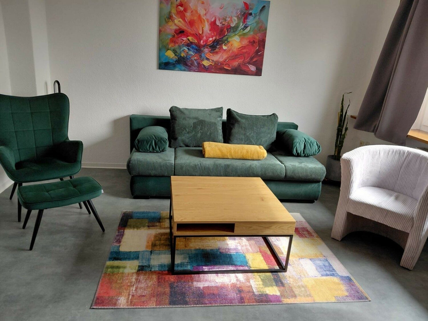 Wohnbereich mit grünem Sofa und Couchtisch