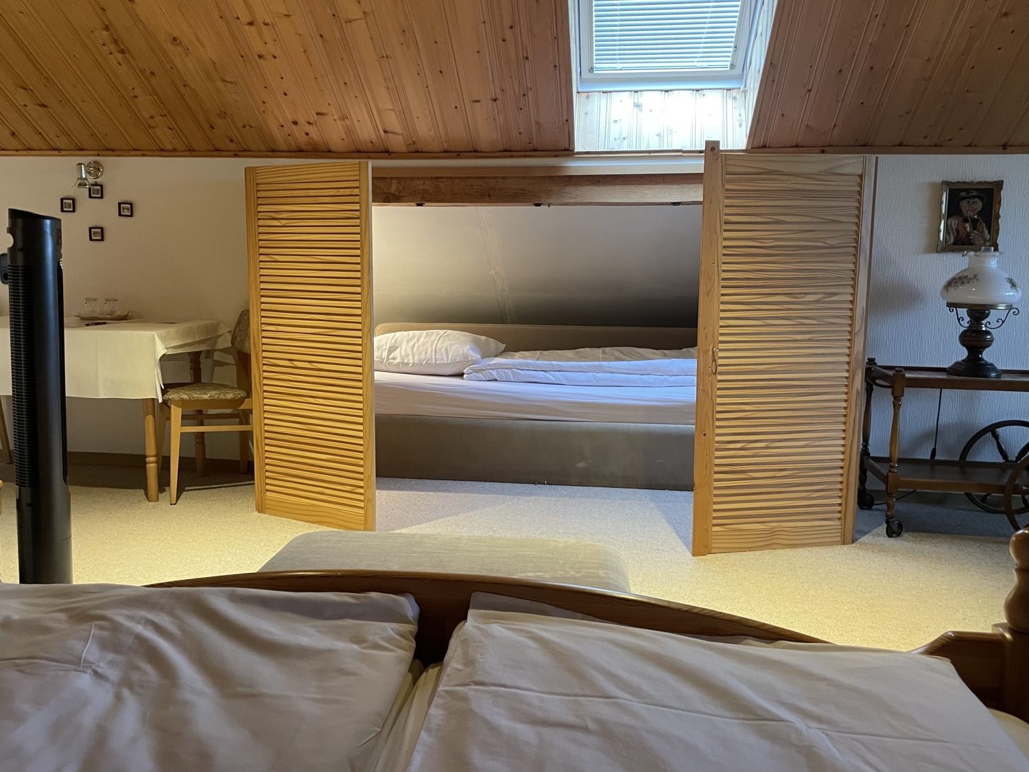 Doppelbett mit Blick durch Holzlamellen