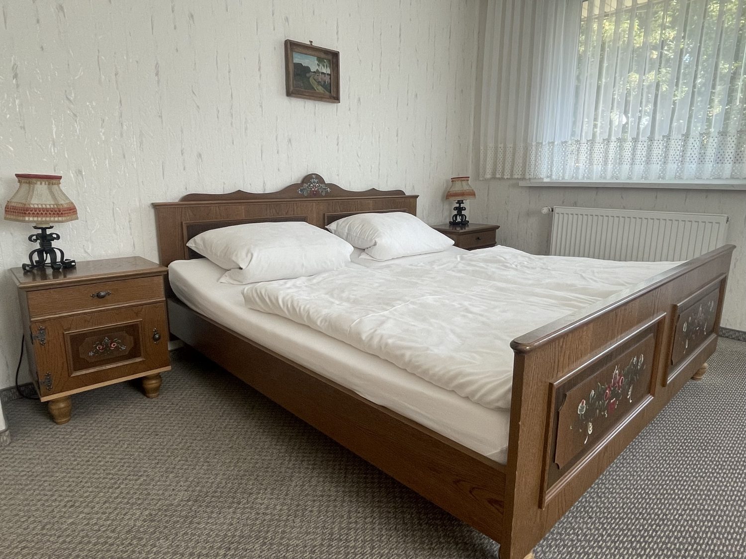 Schlafzimmer mit Doppelbett aus Holz und Nachttischen