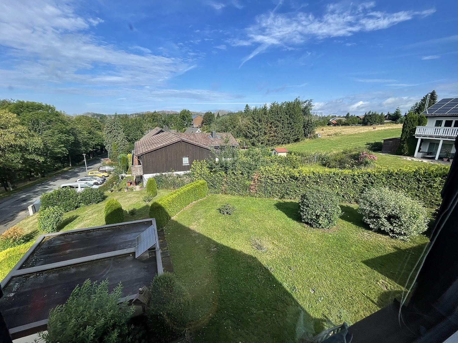 Blick vom Fenster über den Garten im Sommer