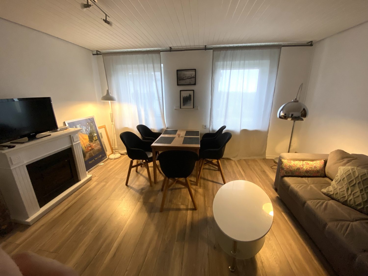 Wohnzimmer mit Fernseher, Essplatz und Sofa