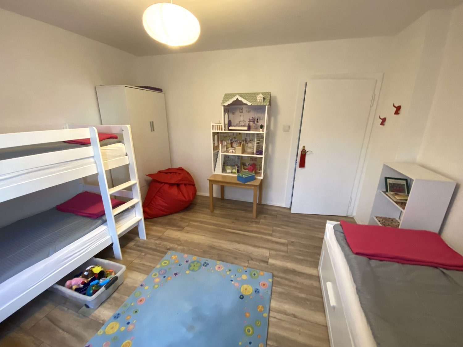 Kinderzimmer mit Etagenbett und Spielteppich